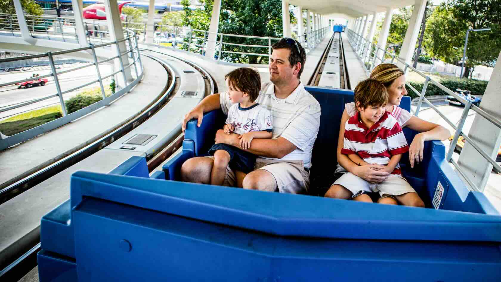 A family rides the Peoplemover through Tomorrowland