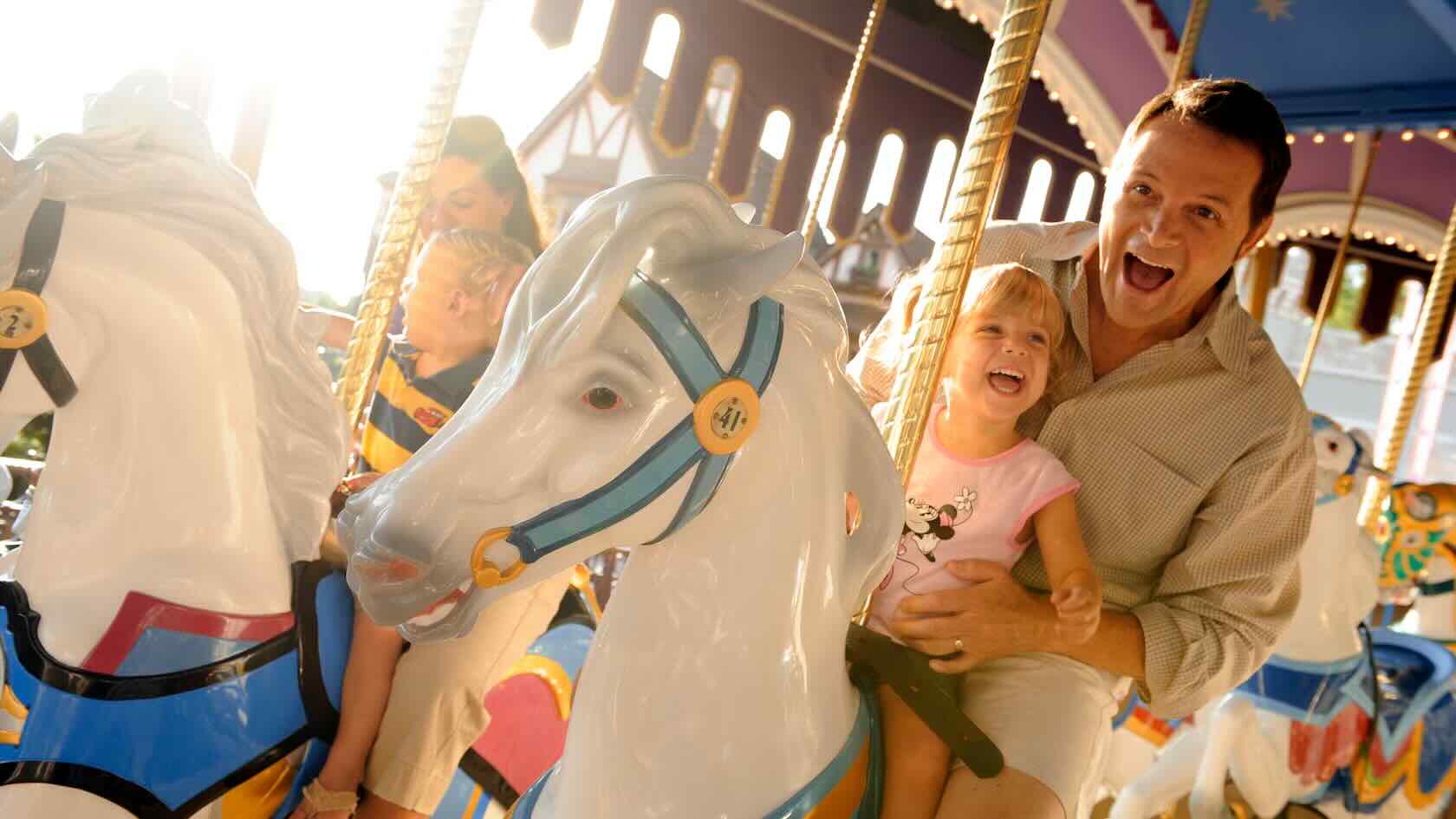 A father and daughter ride a horse on the carousel