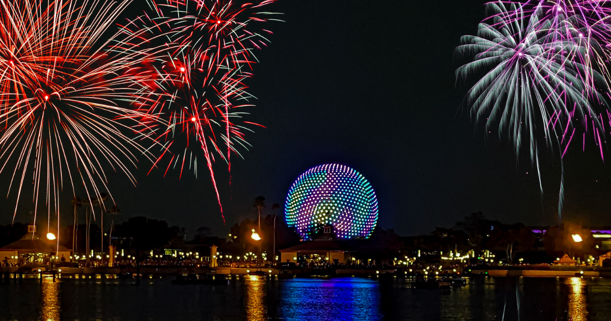 Epcot ball with fireworks lit up at night